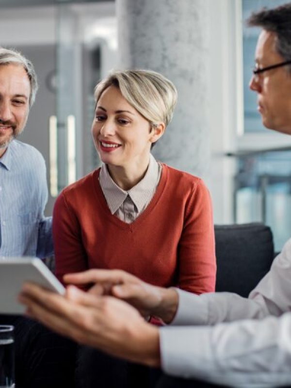 happy-mid-adult-couple-using-touchpad-with-their-financial-consultant-in-the-office--800x533